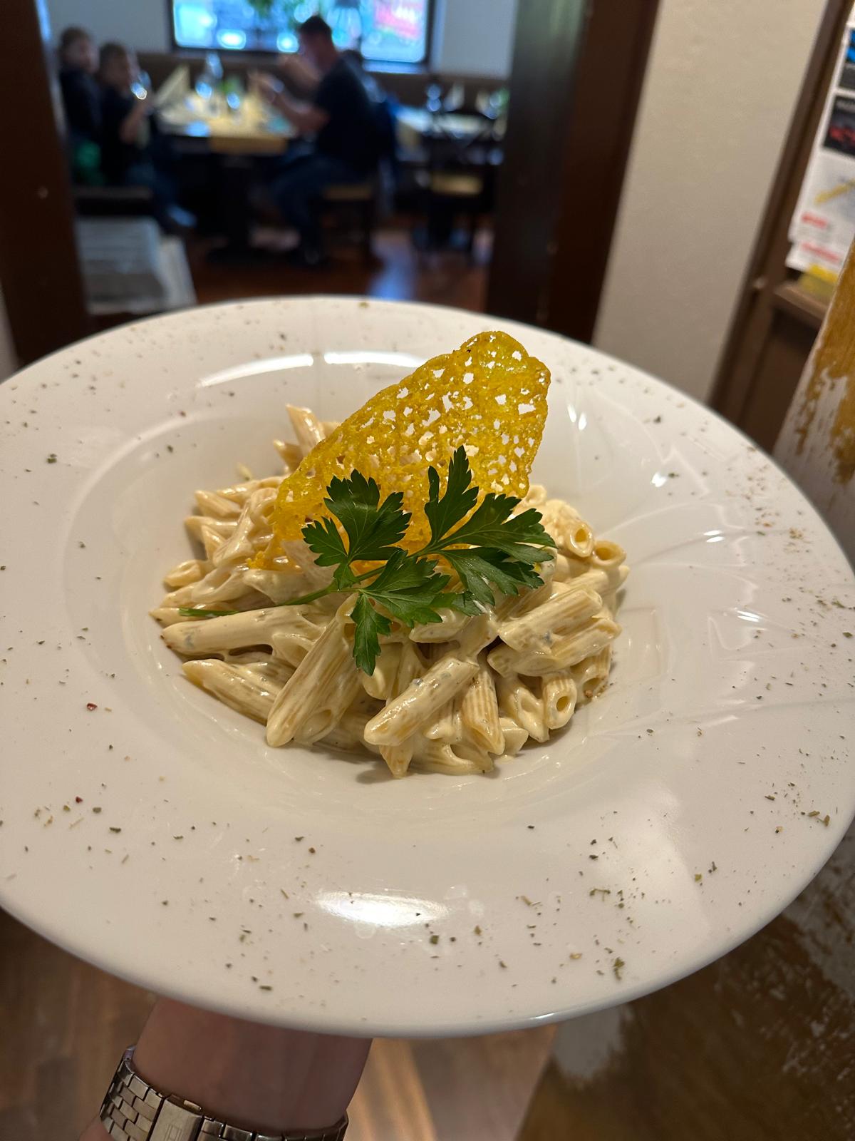 Exquisite Pasta-Kreation mit Parmesanchip